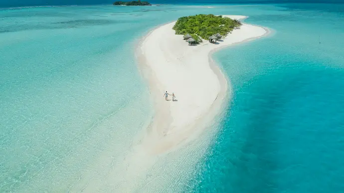 two person walking on islet during daytime